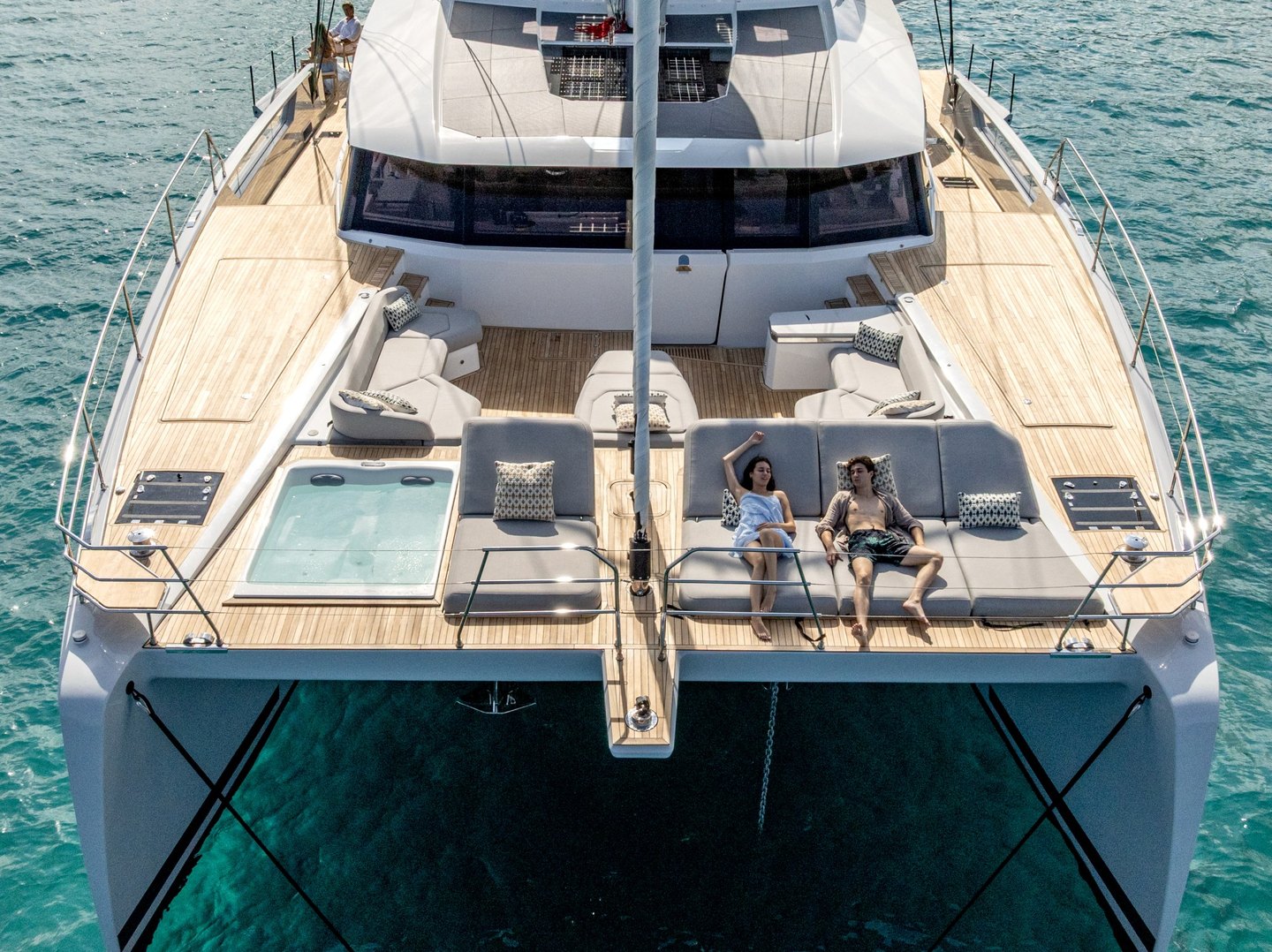 Aerial of the forward cockpit with the Jacuzzi and guests on the sunbeds