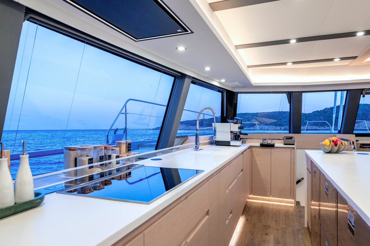 Open galley with induction hob and sea views at dusk