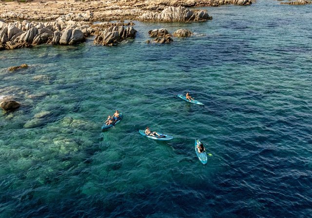 Aerial of kayaks and paddleboards in a turquoise cove